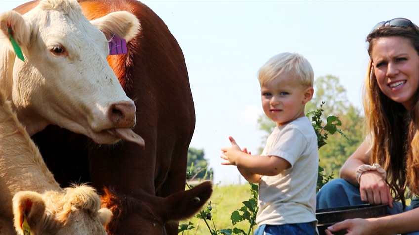 April Patterson and son by cattle